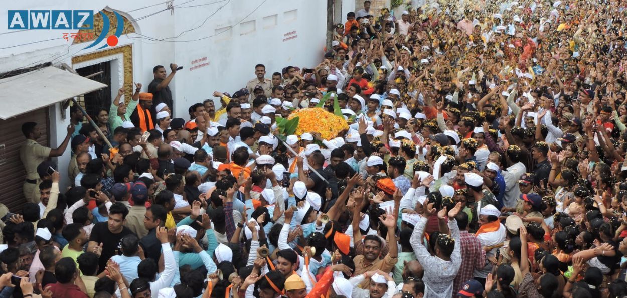 धुळे : खूनी मशिदीजवळ मानाच्या खूनी गणपतीच्या पालखीवर पुष्पवृष्टी करताना हिंदू- मुस्लीम बांधव. (छायाचित्र : गोरख गर्दे)