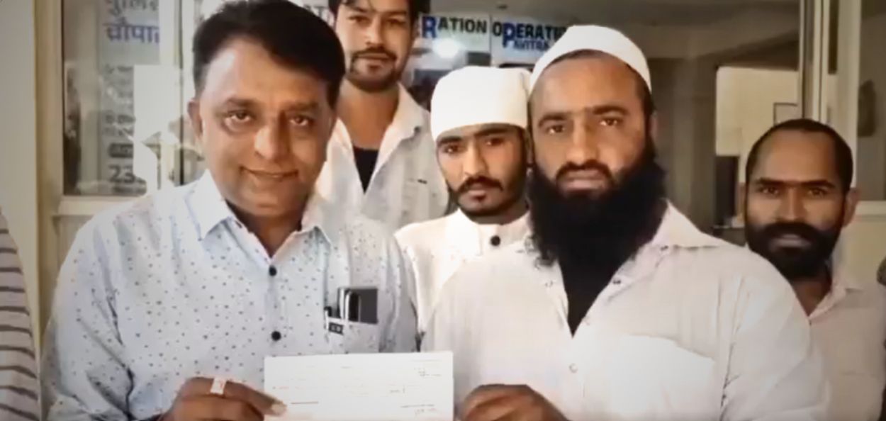 नीलेश नानवानी यांना चेक देताना मोहम्मद युनूस