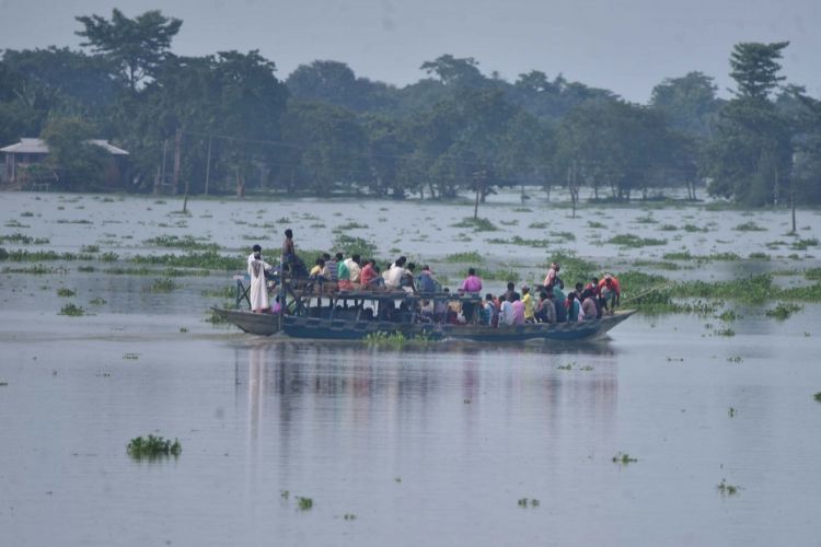 आसाममधील पूरस्थितीत मदत व बचाव कार्य करणारे एनडीआरएफचे जवान आणि पूरग्रस्त नागरिक