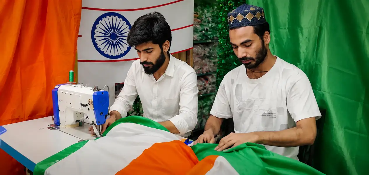 दिल्लीच्या सदर बाजारमध्ये अब्दुल मलिक यांचे कुटुंब राष्ट्रध्वज तयार करताना