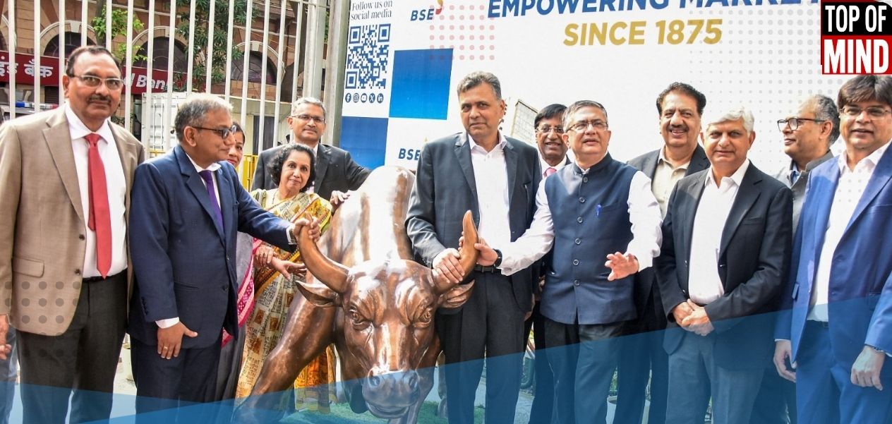 मुंबईतील बीएसई (BSE) येथे 'चार्जिंग बुल' सोबत छायाचित्रासाठी पोझ देताना एनएसईचे (NSE) अध्यक्ष श्रीनिवास इंजेती आणि इतर.